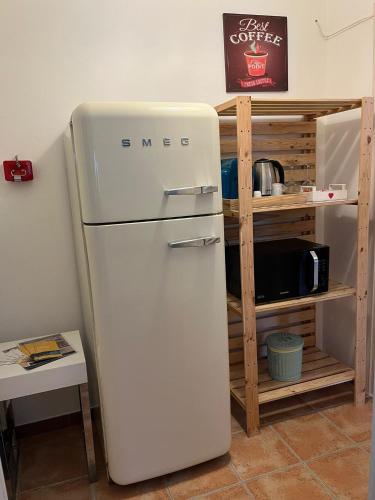 a white refrigerator in a kitchen next to a shelf at Il Giardino Del Nespolo in Arcola