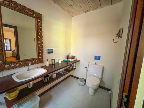 bagno con lavandino, servizi igienici e specchio di Casa do Lord - Natú a Mata de Sao Joao
