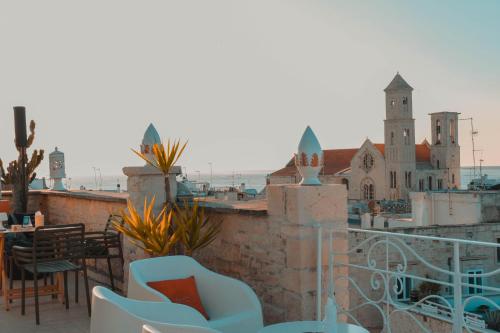 a balcony with chairs and a view of a church at S. Martin Hotel in Giovinazzo