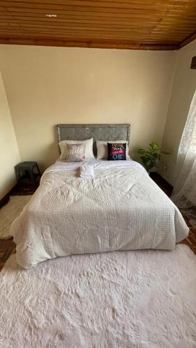 a bed with a white comforter in a bedroom at Riverside Villa in Nairobi