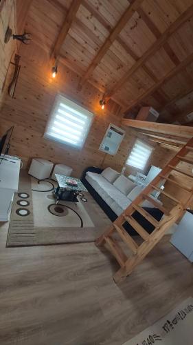 Habitación con cama elevada en una cabaña de madera en Vikendica Monte, en Ledinci