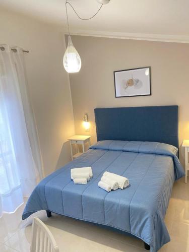 a bedroom with a blue bed with two towels on it at Vista al Tramonto B&B in Falerna