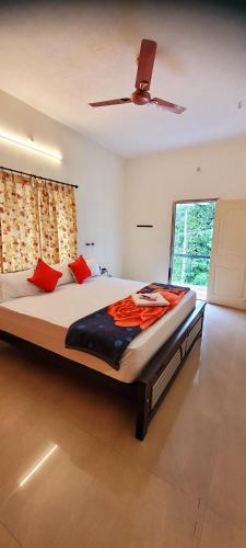 a bedroom with a large bed with a ceiling fan at Black Pepper Cottage Yercaud in Yercaud