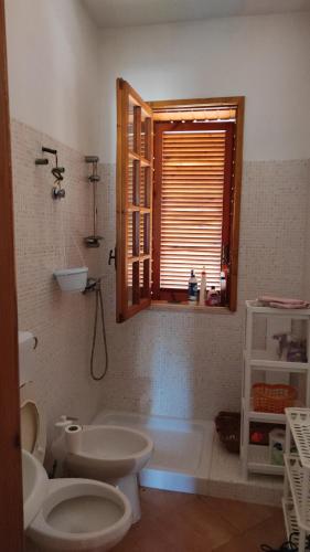 La salle de bains est pourvue de toilettes, d'une baignoire et d'une fenêtre. dans l'établissement La Padula, à Lido Conchiglia