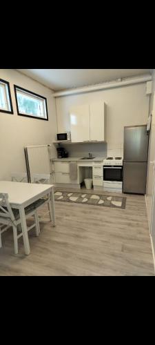 a large kitchen with a table and a refrigerator at Your loft in Seinäjoki