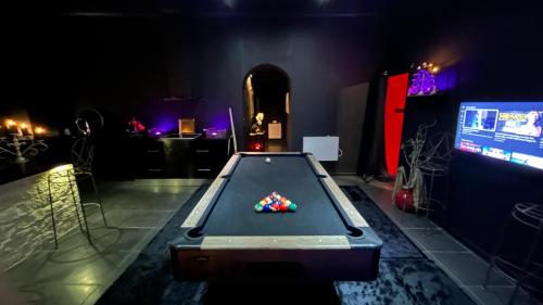 a room with a pool table and a tv at Loft 80m2 avec sauna, spa, table de massage et billard in Milhaud