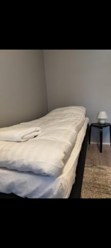 a bed with white sheets on it in a room at Your loft in Seinäjoki