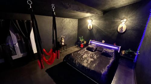 1 dormitorio con 1 cama con luz azul en Loft 80m2 avec sauna, spa, table de massage et billard en Milhaud