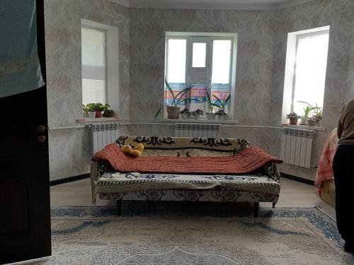 a living room with a couch and two windows at Бурана уютный дом in Döng-Aryk