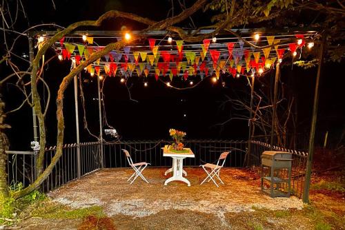 una mesa y sillas bajo una cadena de luces en Robin's house, en Ch'aisubani