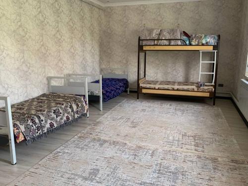 een slaapkamer met 2 stapelbedden en een tapijt bij Бурана уютный дом 