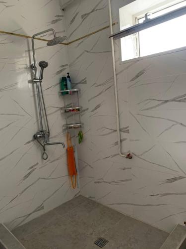 een badkamer met een douche en witte marmeren muren bij Бурана уютный дом 