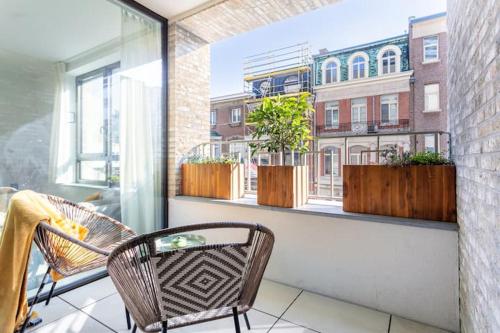Elle comprend un balcon avec deux chaises et une fenêtre ornée de plantes. dans l'établissement Deluxe apartment suite with terrace, à Anvers