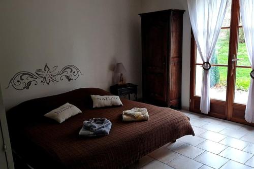 een slaapkamer met een bed met twee handdoeken erop bij Maison chaleureuse avec piscine et SPA en option in Levroux