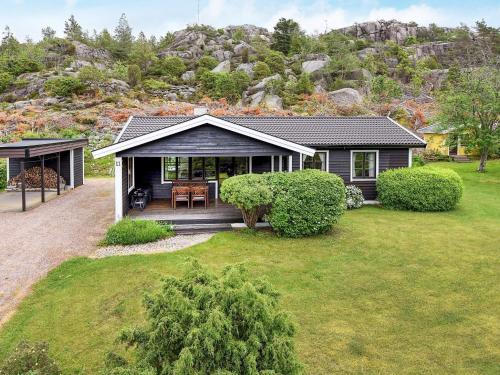 a house with a porch with a grass yard at 7 person holiday home in Bovallstrand in Bovallstrand