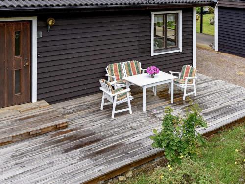 un tavolo e due sedie su una terrazza di legno di 7 person holiday home in Bovallstrand a Bovallstrand