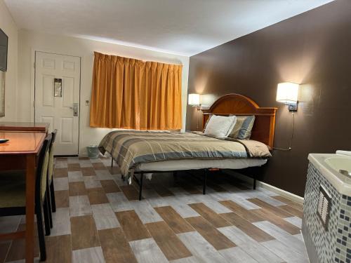 a bedroom with a bed with an orange curtain at Country Club Inn & Suites in Fostoria