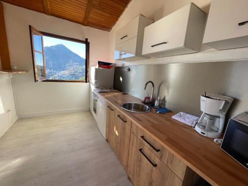 - une cuisine avec un évier et un comptoir avec une fenêtre dans l'établissement Chez eliot, à Vico