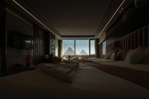 a hotel room with two beds and a large window at The Muse Pyramids INN in Cairo