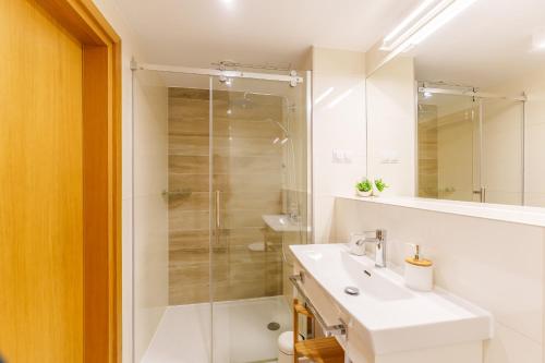 a bathroom with a white sink and a shower at Apartament Prywatny Seaside Park 649 in Kołobrzeg