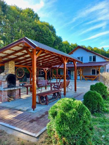 a wooden pavilion with picnic tables and a fireplace at Copacabana 1 in Şinteu