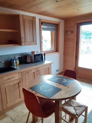 une cuisine avec une table et des chaises dans une pièce dans l'établissement Appartement alp'intages, à Combloux