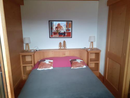 コンブルーにあるAppartement alp'intagesの小さなベッドルーム(青いベッドカバー付)