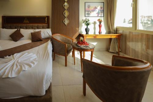 a hotel room with a bed and a table and chairs at The Muse Pyramids INN in Cairo