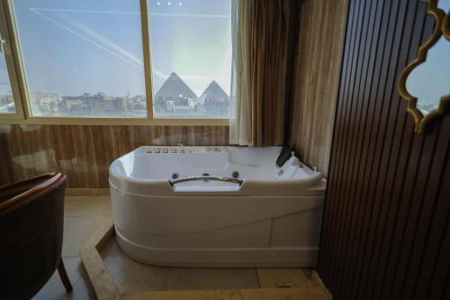 a bath tub in a bathroom with a window at The Muse Pyramids INN in Cairo