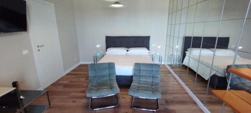 Un dormitorio con dos camas y dos sillas azules. en Glamour suite, en Monopoli