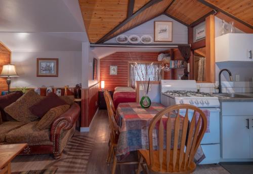 a kitchen and living room with a couch and a table at Hillside Bungalows in Banff