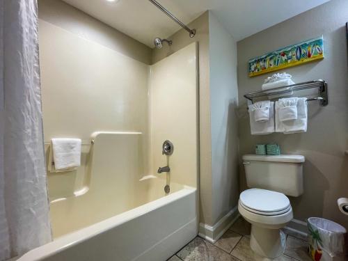 a bathroom with a tub and a toilet and a shower at The Horizon at 77th in Myrtle Beach