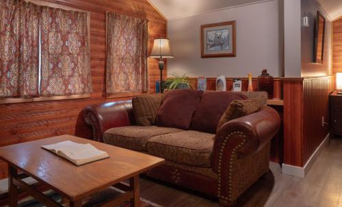 a living room with a brown couch and a table at Hillside Bungalows in Banff