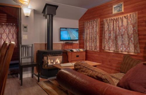 - un salon avec un canapé et une cuisinière dans l'établissement Hillside Bungalows, à Banff