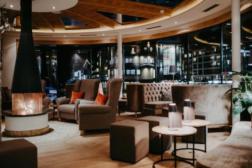 a lobby with chairs and tables and a bar at Hotel Salzburger Hof Zauchensee in Zauchensee