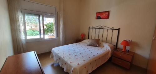 a bedroom with a bed and a table and a window at Apartament Roqueta in Palamós