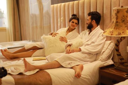 a man and a woman sitting on a bed at The Muse Pyramids INN in Cairo