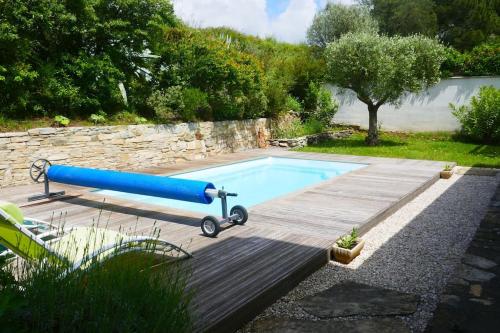 une piscine avec un tuyau bleu dans un jardin dans l'établissement Villa avec piscine dans la garrigue entre Narbonne et Méditerranée, à Armissan