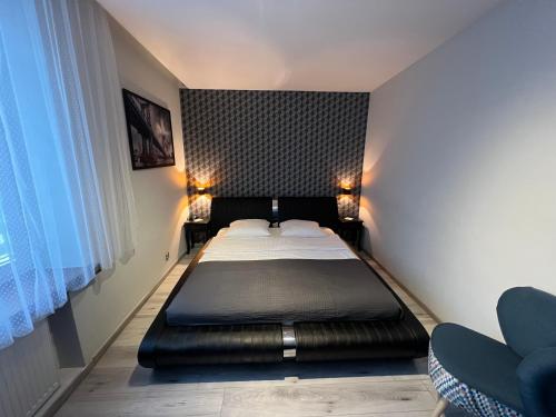 ビャウィストクにあるApartments Gradowaのベッドルーム1室(黒いヘッドボード付きのベッド1台付)