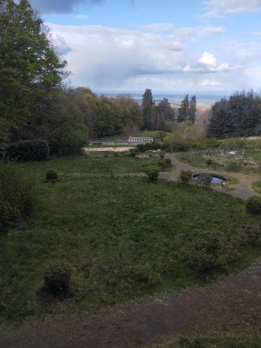 a view of a field with a pond and a bridge at Chambres d'hotes au Domaine des Possibles in Orcines