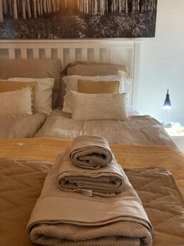 a bed with a blanket and a towel on it at Chic & Zen in Budapest