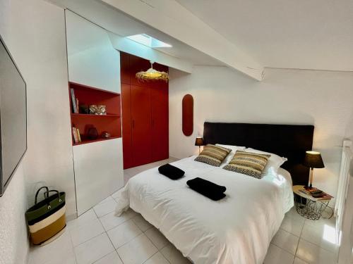 - une chambre avec un grand lit blanc et une porte rouge dans l'établissement Golfes clairs - Duplex climatisé - Wifi, à Argelès-sur-Mer