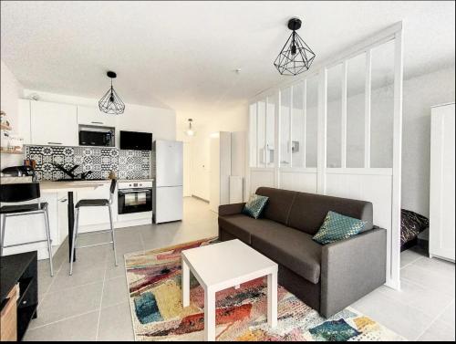 un salon avec un canapé et une cuisine dans l'établissement modern cozy apartment, à Montreuil