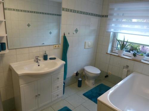 Un baño con lavabo, inodoro y bañera. en Ferienwohnung Schön, en Münchenbernsdorf