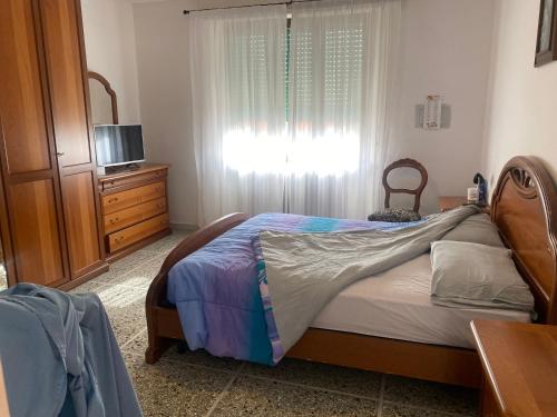 カランブローネにあるCasa al mareのベッドルーム1室(ベッド1台、ドレッサー、窓付)