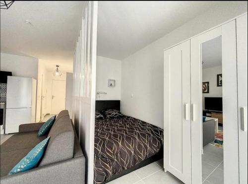 une chambre avec un lit et un canapé dans une pièce dans l'établissement modern cozy apartment, à Montreuil