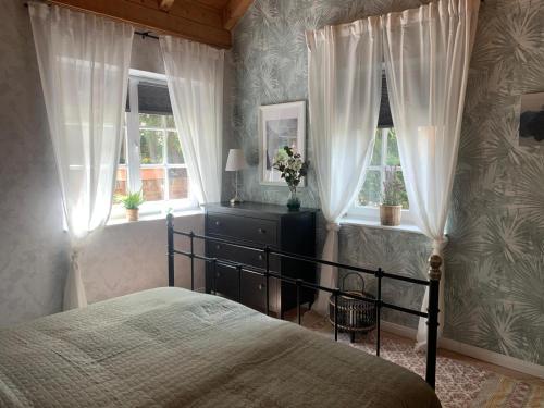 a bedroom with a bed and two windows at Ferienwohnung Landhaus Scholz in Bad Münder am Deister