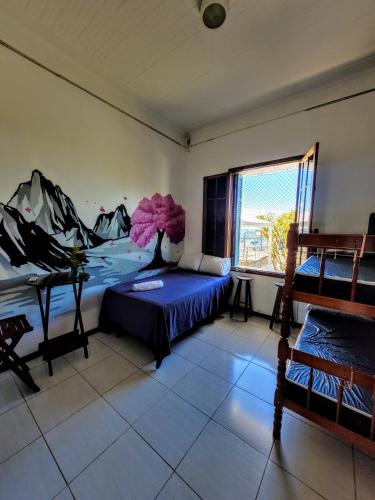 a room with a bed and a vase with pink flowers at Hostel Sunrise in Rio de Janeiro