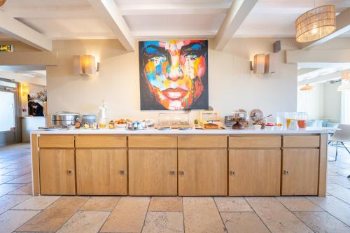 マノスクにあるホテル ル プレ サン ミッシェルの大きな絵画が飾られたキッチン