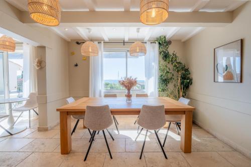 a dining room with a wooden table and chairs at Hôtel Le Pré Saint Michel in Manosque
